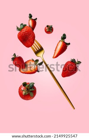Fresh strawberries thrown in the air, with golden fork, flying and levitating on a bright pink background. Creative food concept. Summer berry fruit idea or banner. healthy diet closeup. Royalty-Free Stock Photo #2149925547