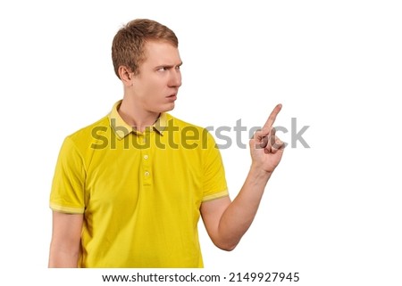 Annoyed young man in yellow T-shirt threatening be more attentive isolated on white background. Disgruntled man gesticulating asking to pay attention and keep in mind, be careful, don't swear Royalty-Free Stock Photo #2149927945