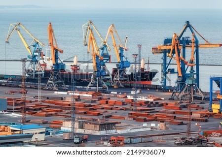 Sea commercial port at night in Mariupol, Ukraine before the war. Industrial. Cargo freight ship with working cranes bridge in sea port at twilight. Cargo port, logistic. Heavy industry Royalty-Free Stock Photo #2149936079