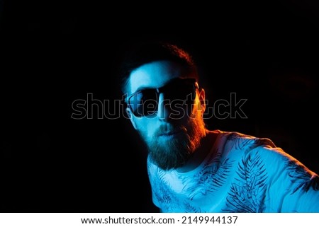 Surprised guy in sunglasses in neon light