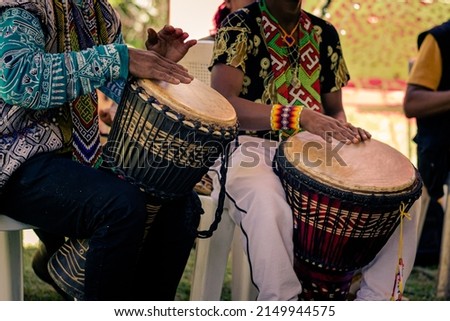 Sao Paulo, SP, Brazil - November 11 2021: Men, with traditional indigenous clothes and handicrafts playing djembe Royalty-Free Stock Photo #2149944575