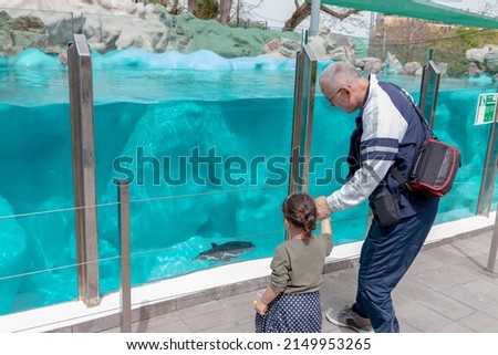 Grandpa and granddaughter enjoy watching penguins underwater