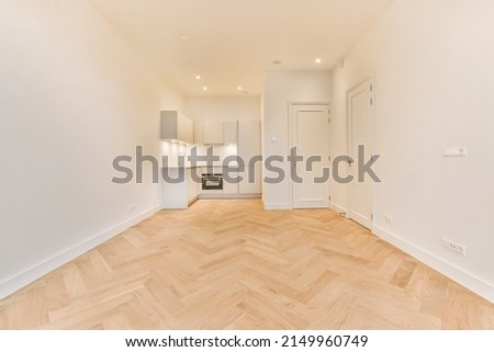 A spacious room with parquet floors and a corner kitchen in a minimalist style in a modern house