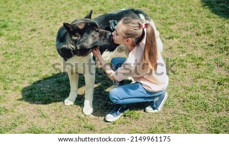 Girl kissing her dog outdoors