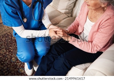 Im here if you need me. Cropped shot of a female nurse hold her senior patients hand.