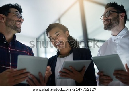 Tech savvy professionals at work. Shot of three colleagues using digital tablets while standing together in an office. Royalty-Free Stock Photo #2149962129