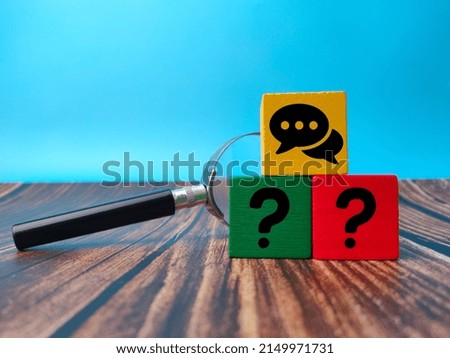 Colored wooden cube with the conversation icon and questions symbol. The concept of questions and answer.