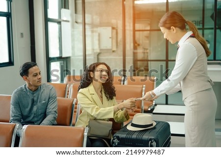 Flight attendant woman checking seats boarding pass and passport on the airplane before flight traveling. Royalty-Free Stock Photo #2149979487