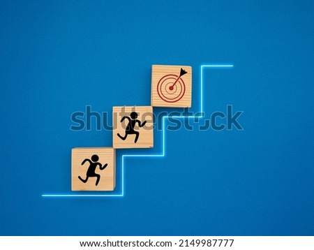 Common goal success concept. Business achieving goal, objective target, and team. Teamwork rises to target and achieves a successful business. Target icon on wooden cubes with a blue background