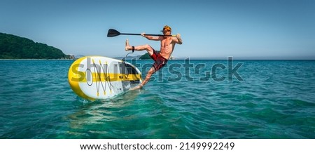 Tanned sportsman falling to sea water practicing supsurfing with paddle extreme sport leisure Royalty-Free Stock Photo #2149992249