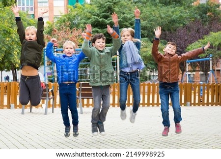 Happy kids jump and play outside. High quality photo