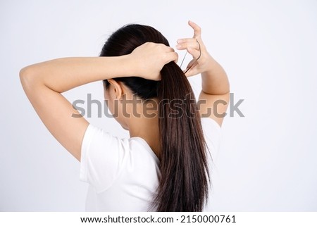 Asian woman tying her hair up isolated on a white background.