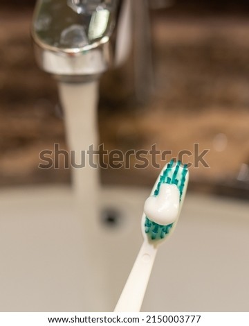 Point of view image of toothbrush with toothpaste on toilet