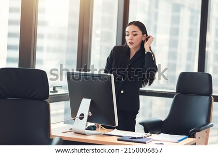 Young adult smart asian business woman in black casual suit working with computer in urban office.