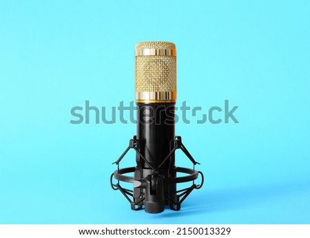 Stand with modern microphone on blue background