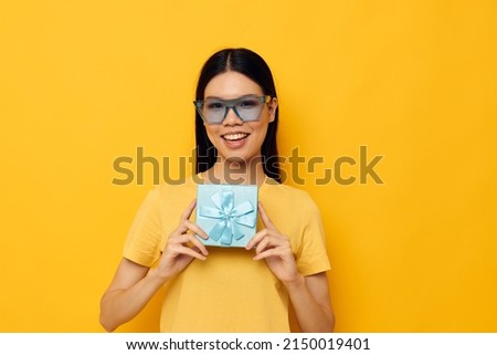 pretty brunette in stylish glasses a gift fun yellow background unaltered