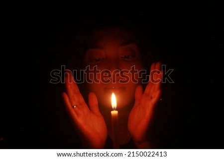 a spooky Asian woman with candle in the dark night