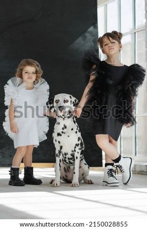 Children's fashion. Little girls pose with a dog in fashionable clothes. High quality photo