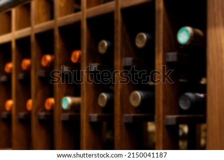 Blurred Red wine bottles stacked on wooden racks
