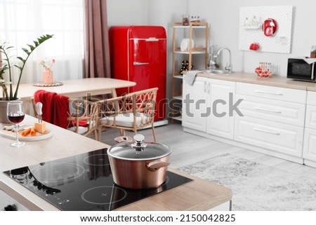 Cooking pot on electric stove in light kitchen Royalty-Free Stock Photo #2150042825