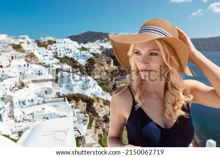 blond woman with a sun hat and a navy blue jumpsuit in Oia on Santorini. High quality photo