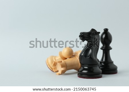 Different chess pieces on light background. Space for text Royalty-Free Stock Photo #2150063745
