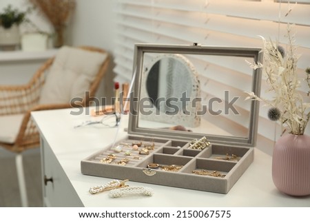 Elegant jewelry box with beautiful bijouterie on commode indoors