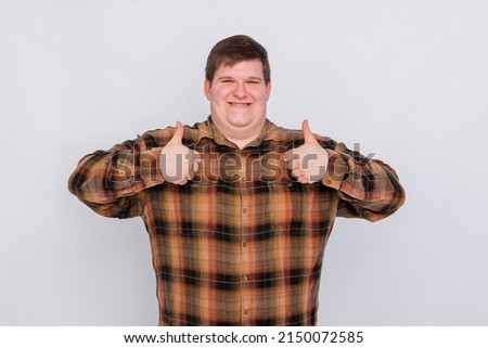 Fat guy showing thumbs up with both hands isolated on white background. Young man making a gesture, I like it, great job. Body language, body positivity.
