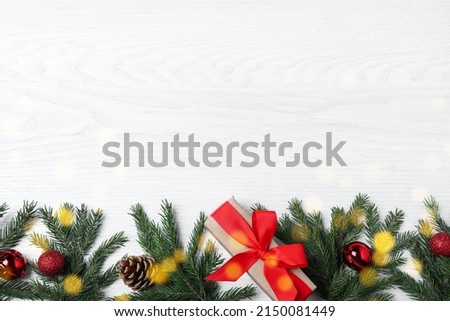 Christmas greeting card with space for text. Flat lay composition of fir tree branches and festive decor on white wooden background