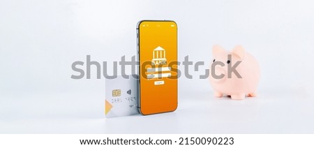 Online payment. Mobile phone with internet online bank app. Pig bank with credit card on white background. Online wallet save money