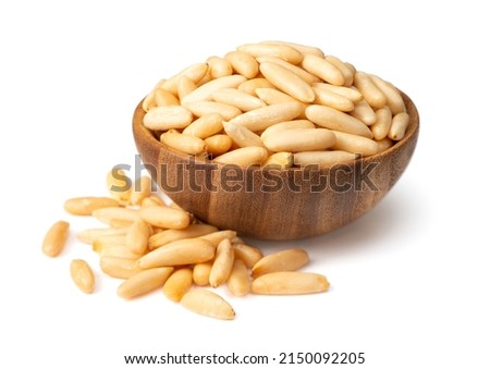 Roasted pine nuts in the wooden bowl. isolated on white background. Royalty-Free Stock Photo #2150092205