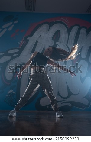 Female dancer against the dark background. Smoke and lights stage setup.