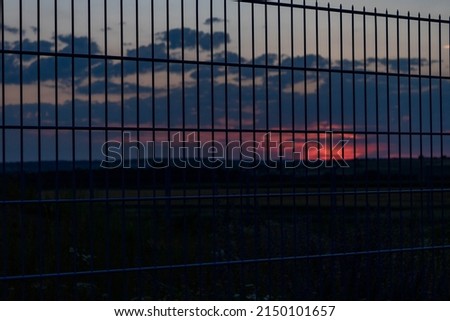 Background with metal grids against sunset sky. Boundary, fence, hope concept