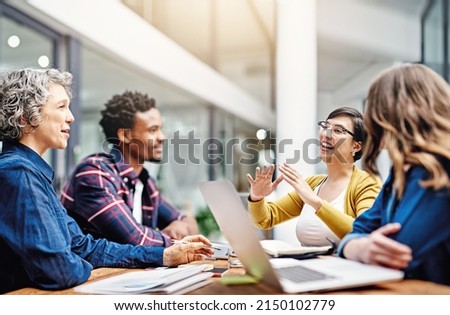 They produce the most dynamic work together. Cropped shot of a group of creatives having a meeting in a modern office. Royalty-Free Stock Photo #2150102779