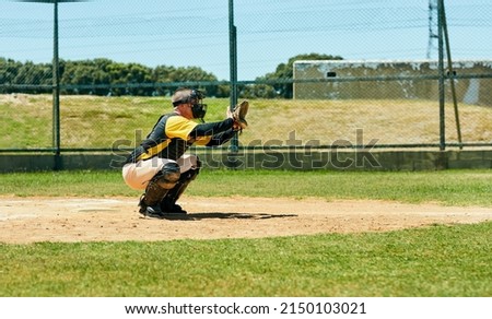 Hes ready to get a good catch. Full length shot of a young baseball player preparing to catch a ball during a match on the field.
