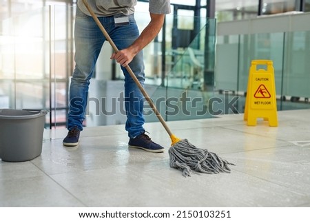 Hell leave that floor spotless. Shot of an unrecognizable man mopping the office floor. Royalty-Free Stock Photo #2150103251