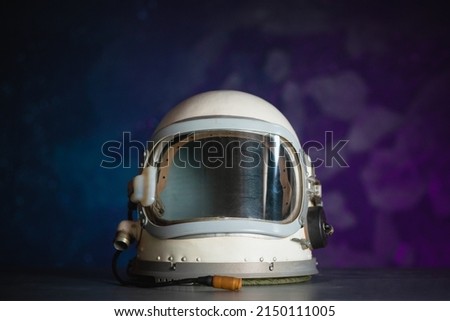 Concept of astronaut helmet on the table on the cosmic background. Royalty-Free Stock Photo #2150111005