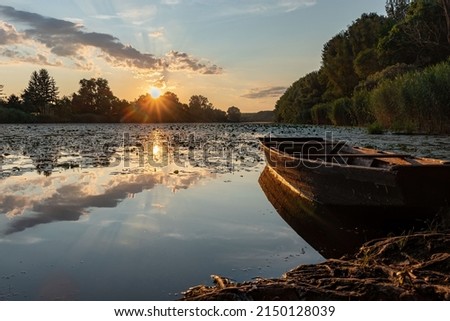 Beautiful landscape photo of the sunrise and small wooden boat in national park Gornje Podunavlje.