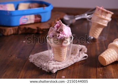 Chocolate and Strawberry Ice cream cone, on a wooden table