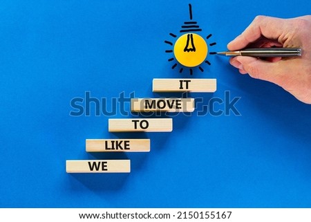 We like to move it symbol. Concept words We like to move it on wooden blocks. Businessman hand. Beautiful blue table blue background. Business motivational We like to move it concept. Copy space.