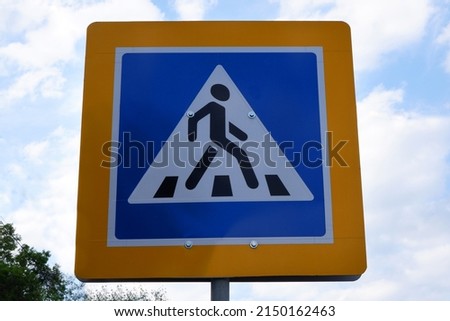 Pedestrian crossing sign against the sky. Road safety concept