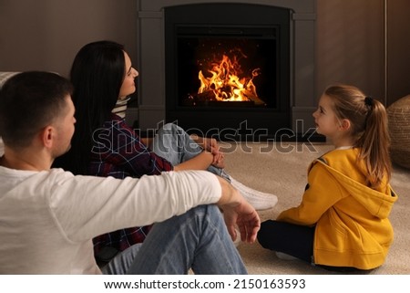 Happy family spending time together near fireplace at home