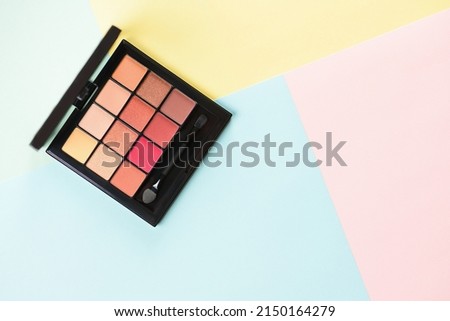Pallet shadows for applying on face on multicolored background. Eye shadow and eyeliner. Womens beauty. Royalty-Free Stock Photo #2150164279