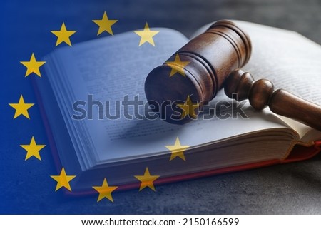 Double exposure of European union flag and book with wooden gavel on grey table