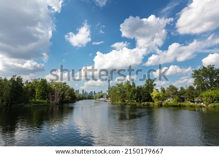 The skyline of Toronto, a view from the lake side - Toronto, Ontario, Canada. Panorama view of the Canadian city of Toronto, with white clouds on a blue sky with the Toronto tower. Urban view of city