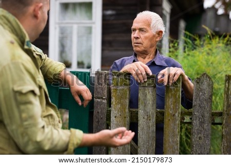 Senior man having conversation with his neighbour Royalty-Free Stock Photo #2150179873