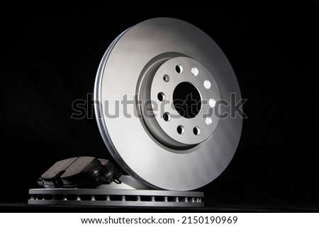 New brake pads and brake discs on a black background. Auto Parts Braking System