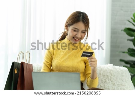 Asian woman in casual clothes is happy and cheerful while communicating with her smartphone and working in a coffee shop.