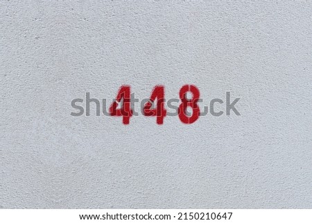 RED Number 448 on the white wall. Spray paint.
