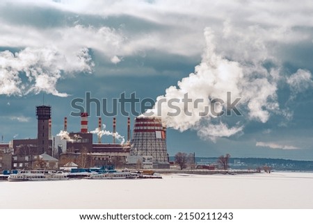 A factory with pipes from which smoke is coming. The plant emits smog into the atmosphere. Ecology of the environment on the territory of an industrial enterprise. Air pollution. Royalty-Free Stock Photo #2150211243